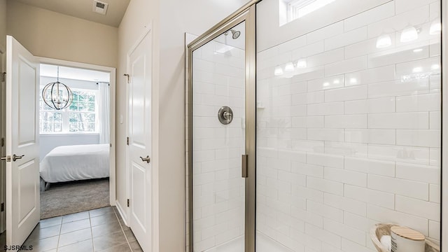 bathroom with tile patterned flooring, a shower with door, and a notable chandelier