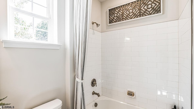 bathroom with toilet and shower / bath combo