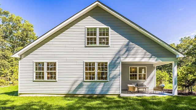 rear view of property with a yard and a patio area