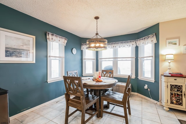 tiled dining area with a textured ceiling