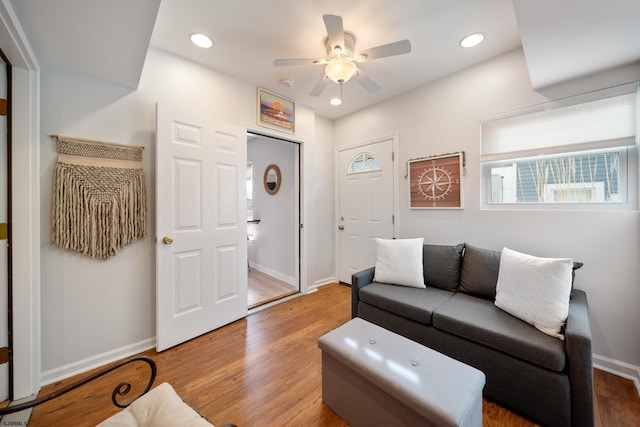 living room featuring wood-type flooring and ceiling fan