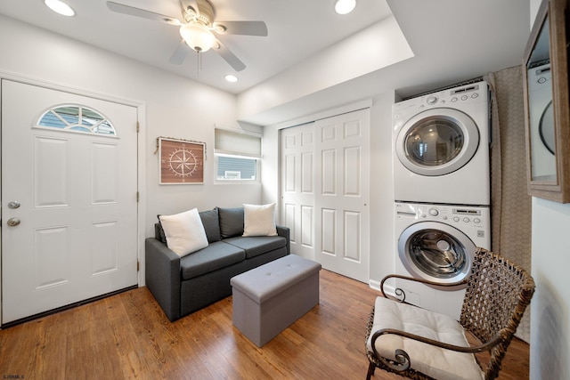 interior space featuring hardwood / wood-style flooring, stacked washer and dryer, and ceiling fan