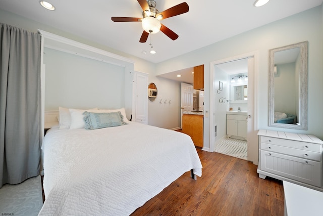 bedroom featuring connected bathroom, dark hardwood / wood-style floors, and ceiling fan