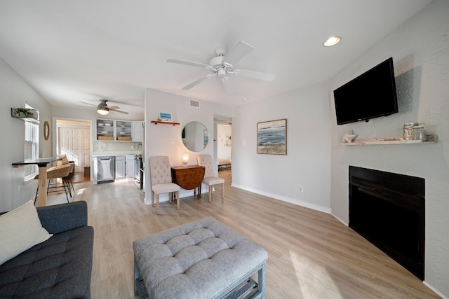 living room featuring ceiling fan and light hardwood / wood-style flooring