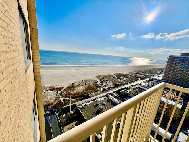 balcony featuring a beach view and a water view