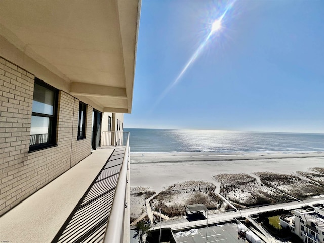 balcony featuring a water view and a beach view