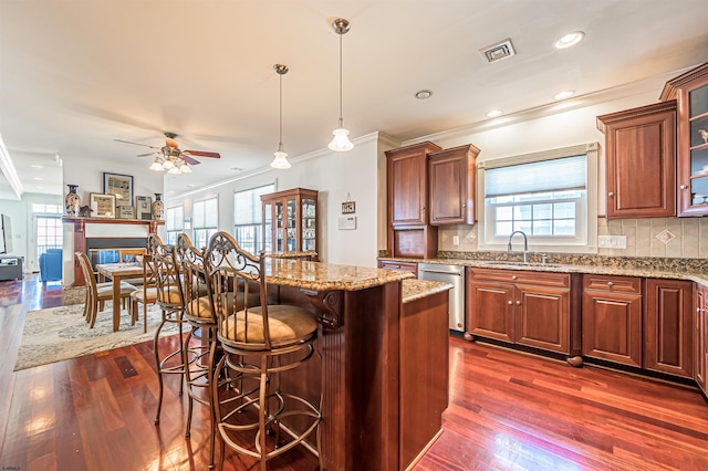 kitchen featuring pendant lighting, stainless steel dishwasher, dark hardwood / wood-style flooring, and a center island