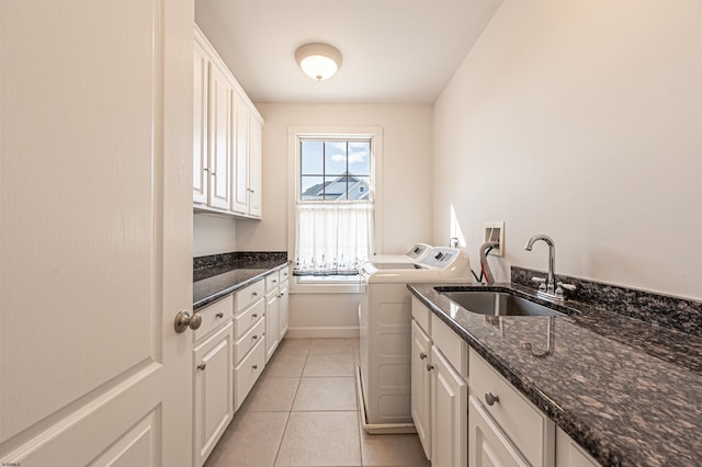 laundry room with sink, light tile patterned floors, washing machine and dryer, and cabinets