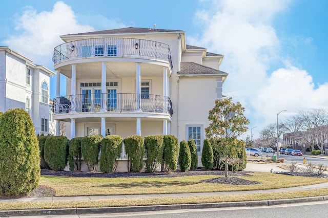 view of front of home with a balcony and a front yard