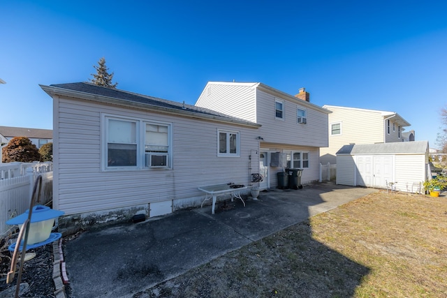 back of property featuring a shed, a lawn, and a patio