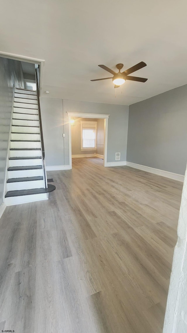 unfurnished living room with light hardwood / wood-style floors and ceiling fan