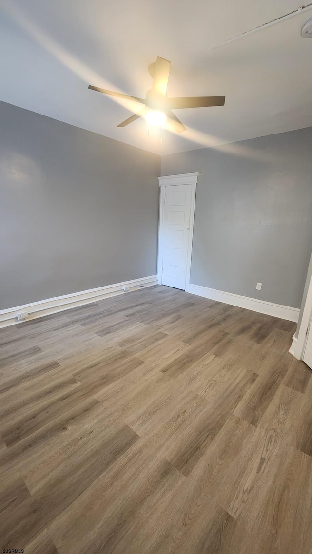 empty room with hardwood / wood-style flooring and ceiling fan