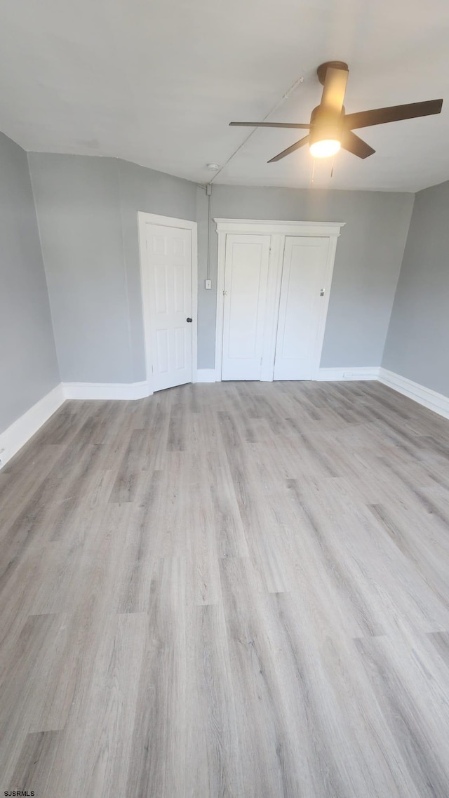 unfurnished bedroom with ceiling fan and light wood-type flooring