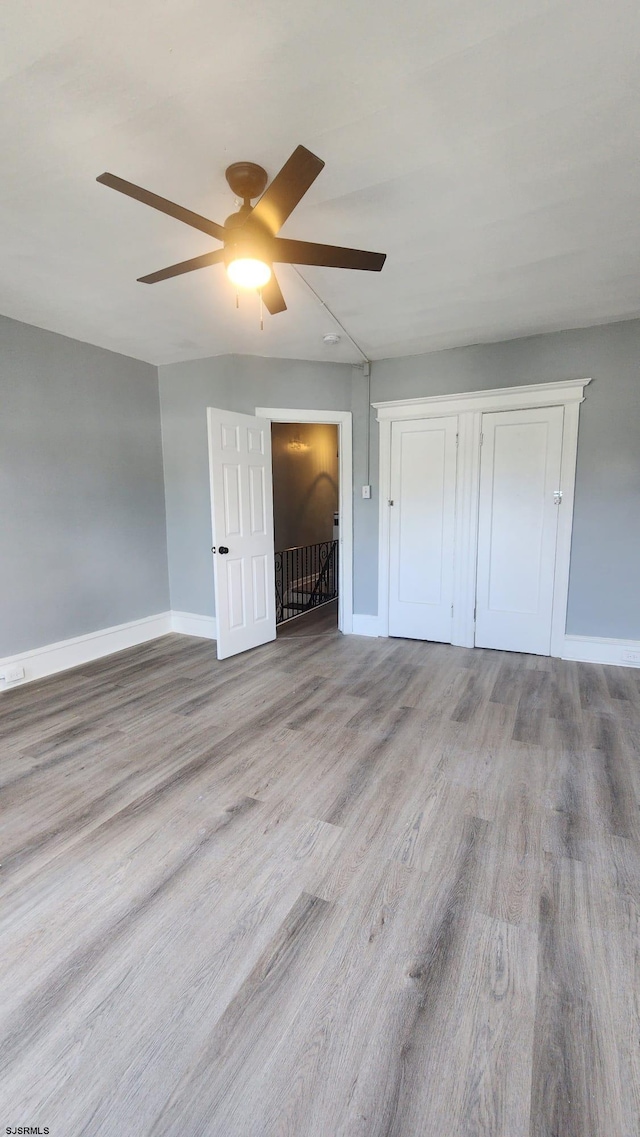 unfurnished bedroom featuring a closet, ceiling fan, and light hardwood / wood-style flooring