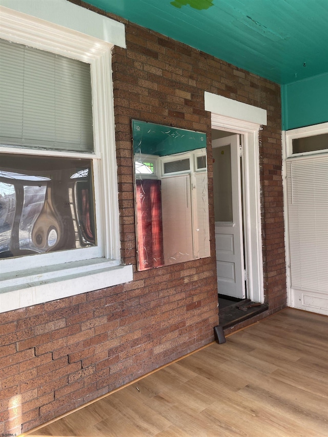 interior space featuring brick wall and hardwood / wood-style floors