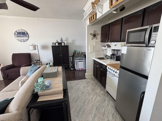 kitchen featuring ceiling fan, dark brown cabinets, stainless steel appliances, ornamental molding, and a textured ceiling