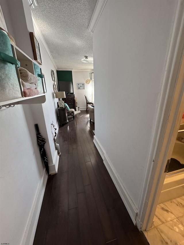 hall with crown molding, dark hardwood / wood-style floors, and a textured ceiling