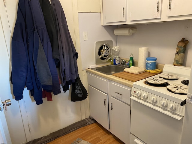 kitchen with light wood-type flooring, white range with gas cooktop, sink, and white cabinets