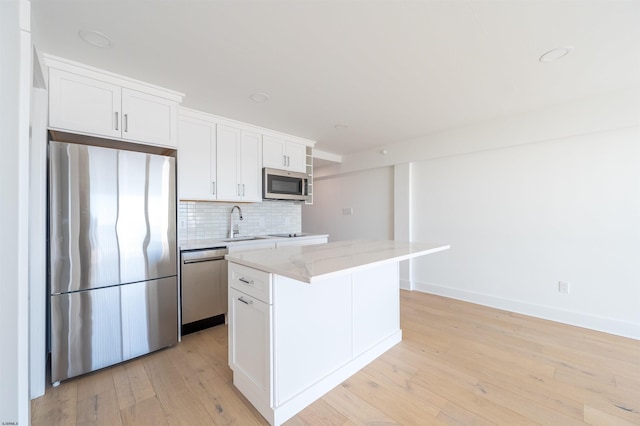 kitchen featuring stainless steel appliances, a center island, and white cabinets