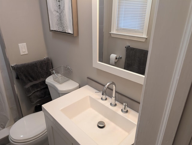 bathroom featuring vanity, curtained shower, and toilet