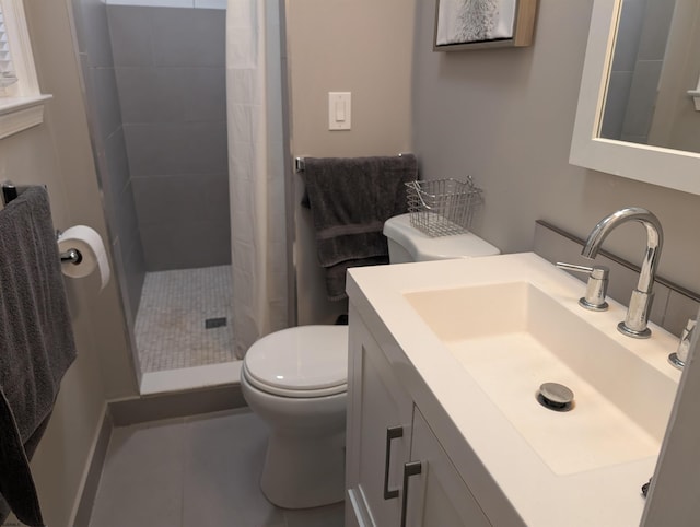 bathroom with tiled shower, vanity, toilet, and tile patterned flooring