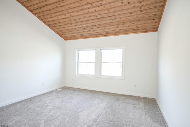 carpeted empty room with high vaulted ceiling and wooden ceiling