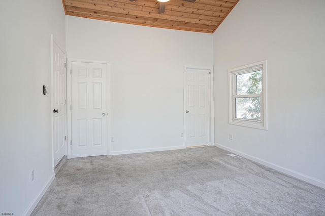 carpeted empty room featuring high vaulted ceiling and wood ceiling