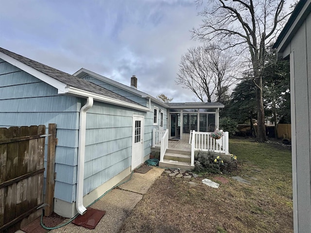 exterior space with a yard and a sunroom