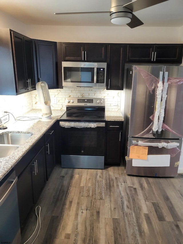 kitchen featuring sink, appliances with stainless steel finishes, hardwood / wood-style flooring, and tasteful backsplash