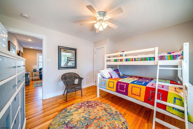 bedroom with ceiling fan, baseboards, and wood finished floors