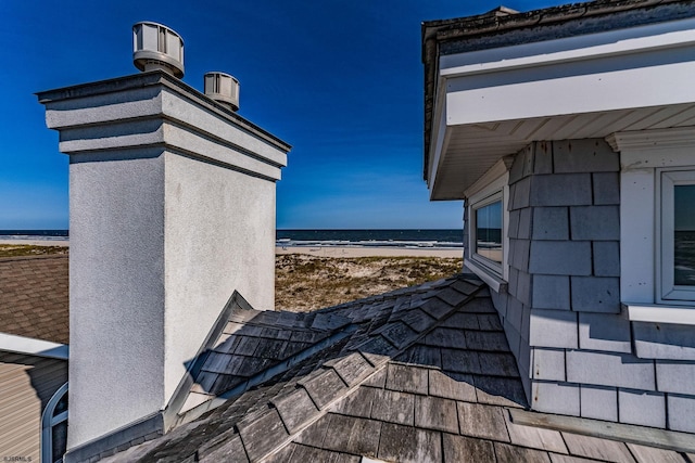 exterior space featuring a water view and a beach view