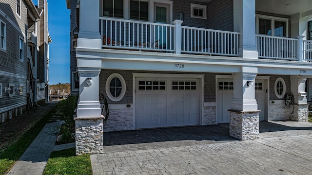 view of front of property featuring a garage and a balcony