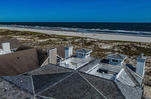 birds eye view of property with a water view and a beach view