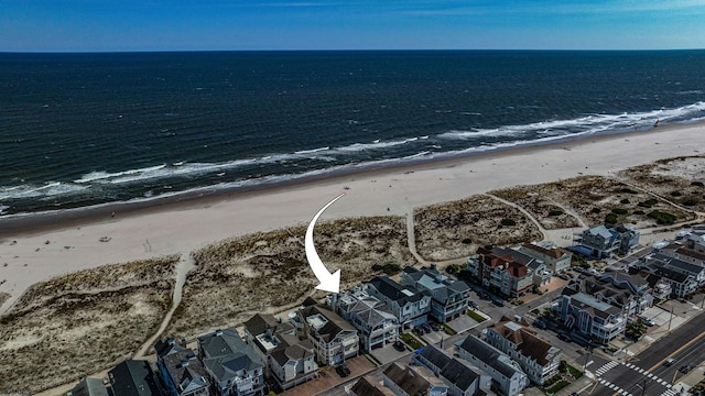 birds eye view of property with a water view and a beach view