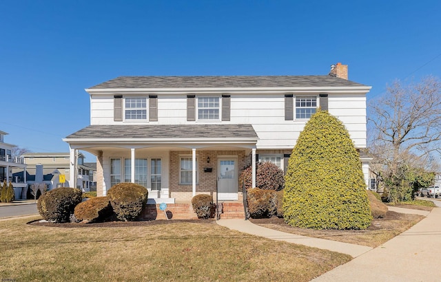 view of front of property with covered porch and a front yard