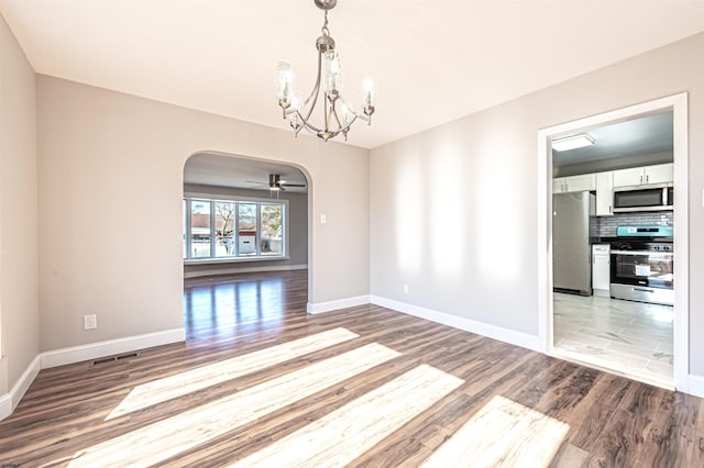 unfurnished room with light wood-type flooring and an inviting chandelier