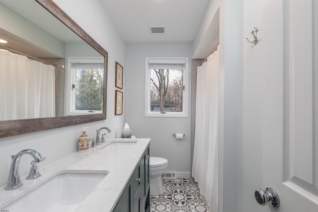 bathroom featuring toilet, plenty of natural light, tile patterned flooring, and vanity