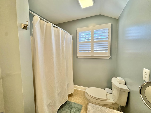 bathroom with tile patterned floors, vaulted ceiling, and toilet