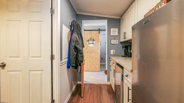 hallway featuring a barn door, crown molding, and dark hardwood / wood-style floors