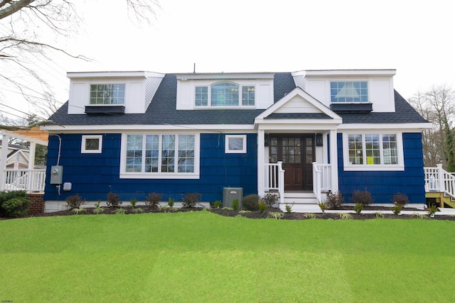 view of front of home with a front yard and central AC unit