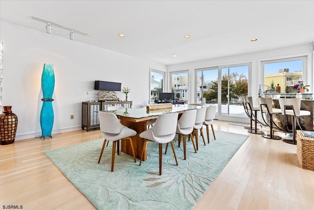 dining space with light wood-style flooring, baseboards, rail lighting, and recessed lighting