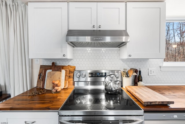 kitchen with range hood, butcher block countertops, stainless steel electric stove, and white cabinets