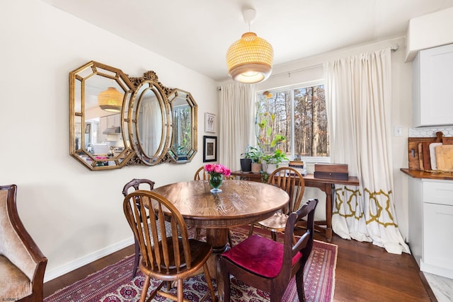 dining room with dark wood-type flooring and baseboards