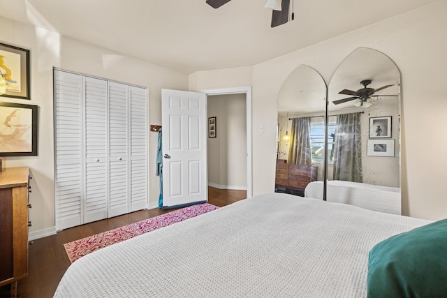 bedroom with ceiling fan, a closet, dark wood finished floors, and baseboards