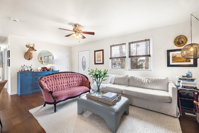 living area with dark wood-type flooring, ceiling fan, and baseboards