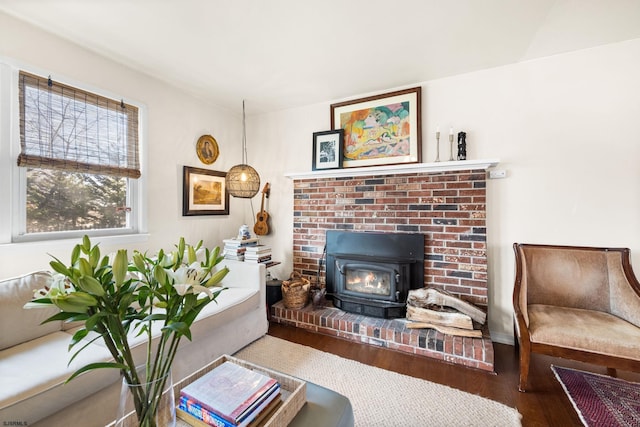 living area with a wood stove and wood finished floors