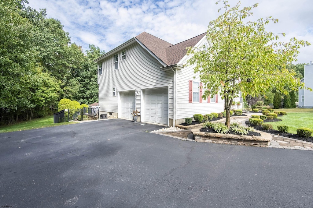 view of front of home featuring a garage, aphalt driveway, and a shingled roof