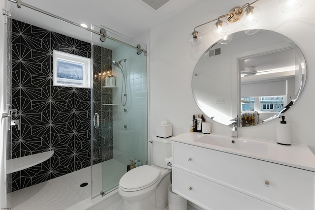 bathroom with toilet, a shower stall, visible vents, and vanity