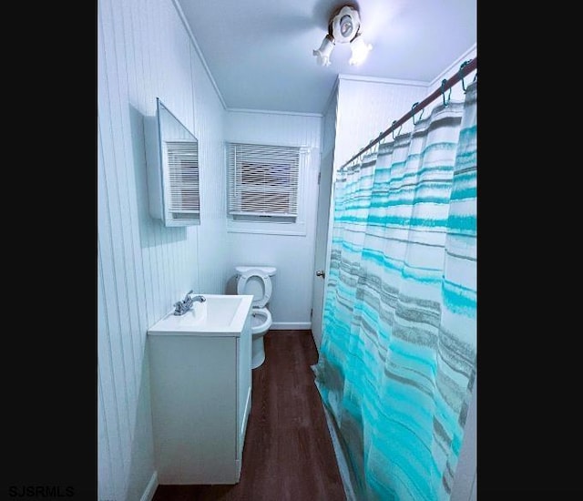 bathroom featuring toilet, a shower with curtain, ornamental molding, wood finished floors, and vanity