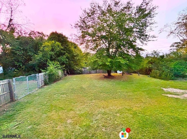 yard at dusk featuring fence